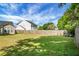 Wide backyard with a green lawn and wooden fence, providing privacy and space for recreation at 129 Mockernut Dr, Ladson, SC 29456