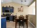 Charming dining area with wood table, chairs, blue cabinets, and modern pendant lighting at 129 Mockernut Dr, Ladson, SC 29456