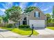 Charming single-Gathering home featuring a well-manicured lawn, lush landscaping, and a two-car garage at 129 Mockernut Dr, Ladson, SC 29456