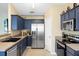 Well-lit kitchen with stainless steel refrigerator and appliances, along with contemporary blue cabinets at 129 Mockernut Dr, Ladson, SC 29456