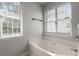 Soaking tub nestled next to sunlit windows in this relaxing bathroom at 132 E Hartwick Ln, Goose Creek, SC 29445