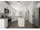 Bright kitchen features white cabinets, stainless steel appliances, an island, and dark accents at 132 E Hartwick Ln, Goose Creek, SC 29445