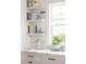 Chic counter space next to a bright window with tastefully arranged cookbooks on shelves at 1331 Smythe St, Daniel Island, SC 29492