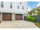 Attached two-car garage with automatic doors, concrete driveway, and verdant landscaping at 1331 Smythe St, Daniel Island, SC 29492