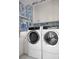 Bright laundry room featuring patterned wallpaper, white cabinetry, and modern washer and dryer at 1331 Smythe St, Daniel Island, SC 29492