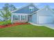 Charming home featuring a two-car garage, a welcoming front yard, and stone accents near the house's entrance at 137 Clydesdale Cir, Summerville, SC 29486