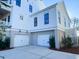Exterior with three garage doors, upper story balconies, and manicured landscaping at 1449 Jeremy Cay Ct, Awendaw, SC 29429