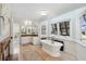 Spacious bathroom with a luxurious soaking tub, fireplace, tile floors, and views of the manicured landscaping at 1511 Fairway Dr, Charleston, SC 29412