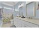 Bathroom with double sink vanity, framed mirrors, and tub-shower with floral curtain at 1513 Cultivation Ln, Mount Pleasant, SC 29466
