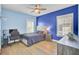 Bright bedroom with blue walls, hardwood floors, ceiling fan, and desk at 1513 Cultivation Ln, Mount Pleasant, SC 29466