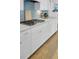 Modern kitchen features white cabinets, light countertops, and a blue tiled backsplash at 1513 Cultivation Ln, Mount Pleasant, SC 29466
