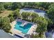Aerial view of the community pool and tennis courts with seating, palm trees, and a manicured lawn at 1551 Ben Sawyer Blvd # 44, Mount Pleasant, SC 29464