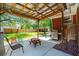 Relaxing covered patio with a stainless steel grill, picnic table, and backyard view for outdoor enjoyment at 1915 Aichele Dr, North Charleston, SC 29406