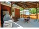 Cozy covered patio featuring a stainless steel grill, picnic table, and steps leading to the backyard at 1915 Aichele Dr, North Charleston, SC 29406