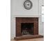 Close-up of the brick fireplace featuring a rustic mantel and a decorative clock above at 1915 Aichele Dr, North Charleston, SC 29406