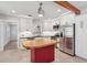 Bright kitchen features white cabinets, stainless steel appliances, an island with butcher block top, and a decorative wood beam at 1915 Aichele Dr, North Charleston, SC 29406