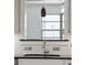 Close up of the kitchen sink featuring white subway tile, stainless fixtures, and an over-the-sink passthrough to the living area at 1915 Aichele Dr, North Charleston, SC 29406