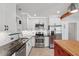 Modern kitchen featuring stainless appliances, granite counters, white cabinets, and a central island with butcher block top and red base at 1915 Aichele Dr, North Charleston, SC 29406