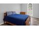 Cozy bedroom with a wooden bed frame, blue bedding, and a natural light-filled window at 1918 Armory Dr, Mount Pleasant, SC 29466