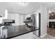 Spacious kitchen featuring white cabinets, black countertops, stainless steel refrigerator, and an open layout at 1918 Armory Dr, Mount Pleasant, SC 29466