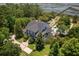 Elegant home with inviting pool, surrounded by manicured landscaping, trees, and waterfront view at 1972 Long Creek Rd, Wadmalaw Island, SC 29487