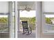 Balcony with rocking chair overlooking lush greenery and serene waterway at 1972 Long Creek Rd, Wadmalaw Island, SC 29487