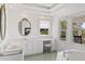 Bright bathroom featuring double sink vanity, large mirror, soaking tub, and natural light at 1972 Long Creek Rd, Wadmalaw Island, SC 29487
