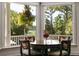 Cozy dining area with views, featuring stylish table and chairs overlooking lush greenery at 1972 Long Creek Rd, Wadmalaw Island, SC 29487