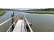 Private dock with a boat lift and railing on the water, offering access to waterways at 1972 Long Creek Rd, Wadmalaw Island, SC 29487