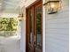 Close-up of the front door with decorative lanterns on a porch at 1972 Long Creek Rd, Wadmalaw Island, SC 29487