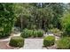Manicured garden featuring lush greenery, palm trees, and a peaceful seating area at 1972 Long Creek Rd, Wadmalaw Island, SC 29487