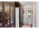 Inviting hallway featuring hardwood floors, elegant built-in cabinets, and ample natural light at 1972 Long Creek Rd, Wadmalaw Island, SC 29487