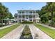 Two story home with double porches overlooking landscaped backyard with fountains and pool at 1972 Long Creek Rd, Wadmalaw Island, SC 29487