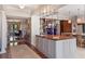 Stylish kitchen bar with seating and elegant glass shelving showcases modern design at 1972 Long Creek Rd, Wadmalaw Island, SC 29487
