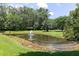 Picturesque pond with a fountain, surrounded by well-maintained lawn and mature trees at 1972 Long Creek Rd, Wadmalaw Island, SC 29487