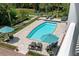 Aerial view of a private pool surrounded by lounge chairs and umbrellas on a sunny day at 1972 Long Creek Rd, Wadmalaw Island, SC 29487