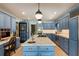 Spacious kitchen features blue cabinets, a marble island with a sink, and pendant lighting at 2 Pierates Cruz, Mount Pleasant, SC 29464