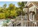 Pool with white railings is surrounded by trees and shrubbery at 2 Pierates Cruz, Mount Pleasant, SC 29464