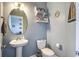 Powder room featuring pedestal sink, toilet, nautical decor, and a glimpse into an adjacent living space at 2113 Pimlico Dr, Ridgeville, SC 29472