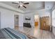 Bedroom features a ceiling fan, light wood-look floors, a dresser with a television, and access to a bathroom at 2113 Pimlico Dr, Ridgeville, SC 29472