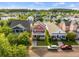 Aerial view of a vibrant neighborhood showcasing a charming red two-story home with a inviting front porch at 218 Barberry St, Summerville, SC 29483