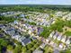 An aerial view of a colorful neighborhood with tree-lined streets near a tranquil pond at 218 Barberry St, Summerville, SC 29483