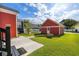 A charming backyard with green grass, a pathway, and a detached garage at 218 Barberry St, Summerville, SC 29483