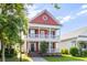 Charming two-story home with double porches, a red facade, and a professionally landscaped front yard at 218 Barberry St, Summerville, SC 29483