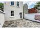 Inviting backyard patio with unique tiled surface, white privacy wall and access door at 23 Felix St, Charleston, SC 29403