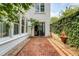 Beautiful backyard with brick patio, garden fountain, lush greenery, and string lights at 23 Felix St, Charleston, SC 29403