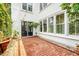 Charming backyard featuring brick patio, large windows, and lush greenery for relaxing at 23 Felix St, Charleston, SC 29403