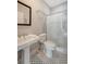 Well-lit bathroom featuring a pedestal sink, a toilet, and a tiled shower with glass doors at 23 Felix St, Charleston, SC 29403