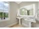 Elegant bathroom with dual pedestal sinks, a large illuminated mirror, and a window with natural light at 23 Felix St, Charleston, SC 29403