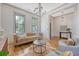 Elegant living room featuring wood floors, chandelier, comfortable seating, and natural light at 23 Felix St, Charleston, SC 29403